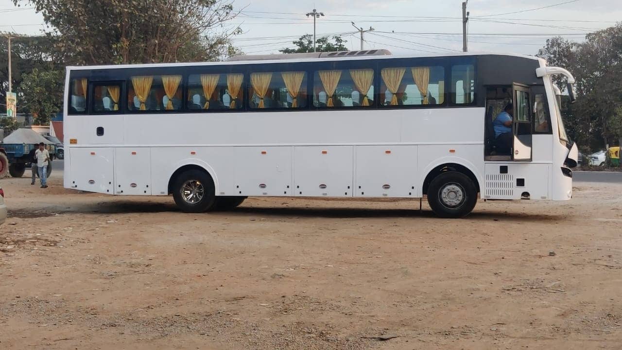 A Sri Subramanyaswamy Tours & Travels tourist coach, full side profile, on open ground