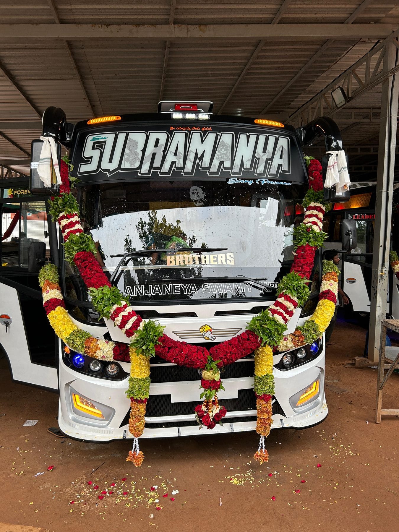 Coach garlanded with flowers before a temple trip